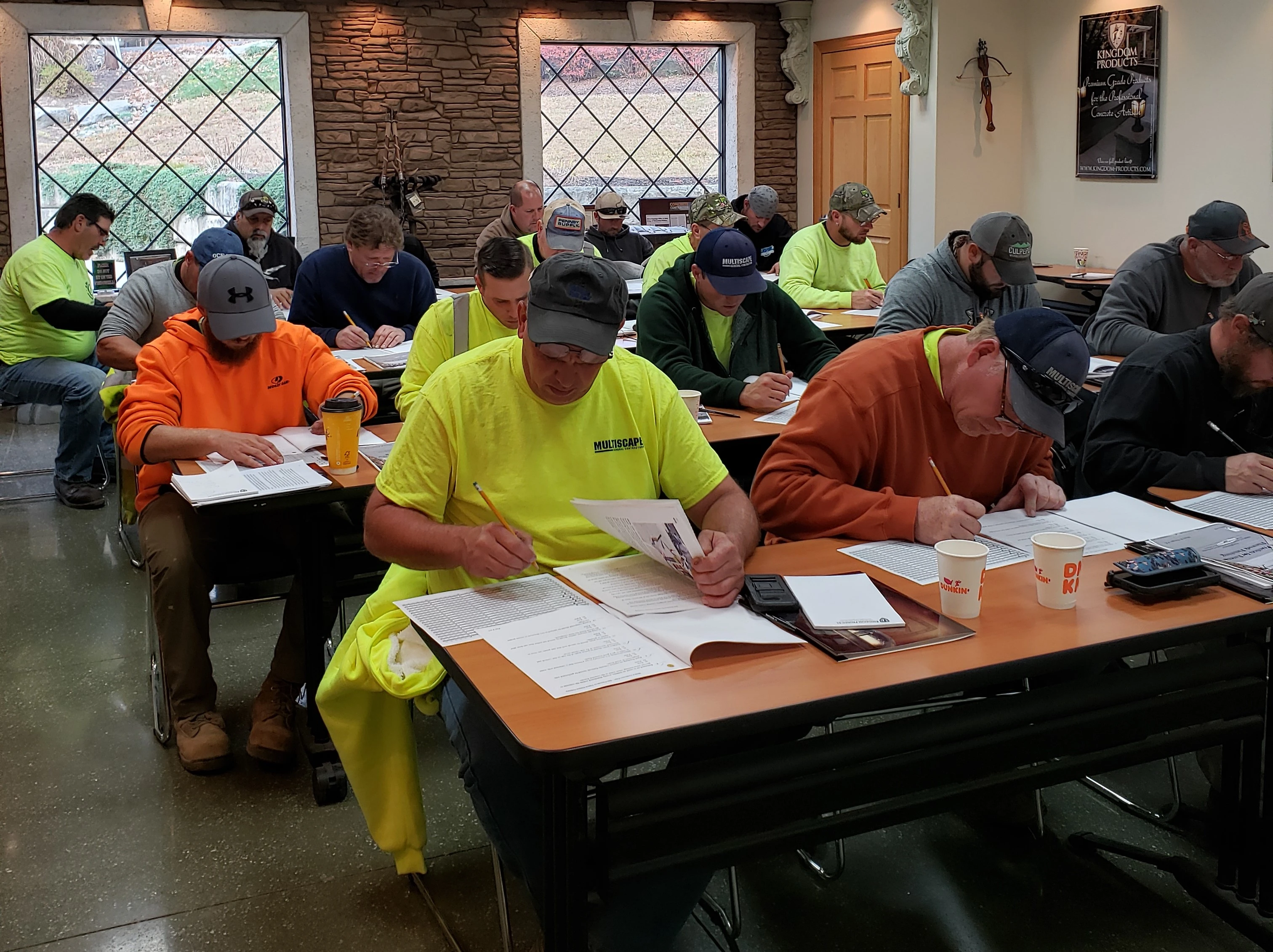 An image of Certified Concrete Finishers Course attendees sitting in a classroom reviewing over course materials during the in-classroom portion of the training.